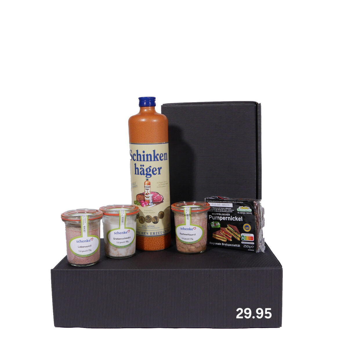 Geschenkbox mit einer Flasche Schnaps, drei Gläsern mit Leberwurst, Griebenschmalz und Rinderwurst sowie einer Packung Pumpernickel-Brot, alles auf einem schwarzen Karton präsentiert mit dem Preis von 29,95.