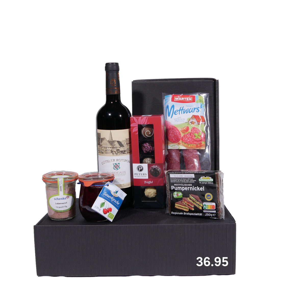 Geschenkbox mit einer Flasche Rotwein, Mettwurst, Trüffeln, Pumpernickel, Leberwurst und Erdbeerkonfitüre, Preisangabe 36,95.